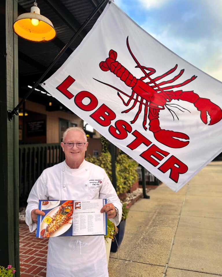 Chef Mike Rumplik featured in Visit Orlando Cookbook in front of The Nauti Lobstah named best seafood restaurant in Orlando